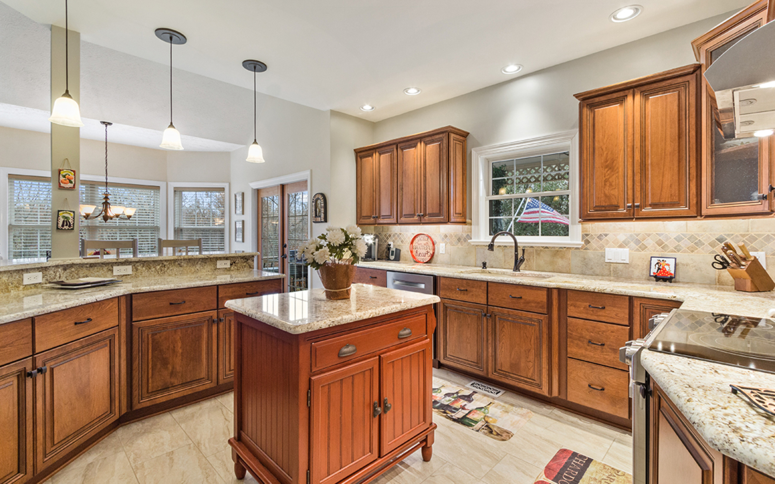 Hardwood maple kitchen cabinets and quartz countertop with island, refaced kitchen with open floor plan in Wilmington, DE by Lowe’s National Refacing Systems.